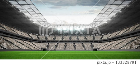 Flat green grass football pitch is extending under roof canopy with floodlights against cloudy sky 133328791