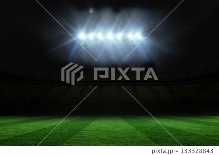 Illuminated striped grass field is shining inside flat stadium design, with floodlights glowing 133328843