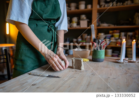 Female potter artist hands molding raw clay. Woman ceramist in apron prepare for shaping pottery 133330052