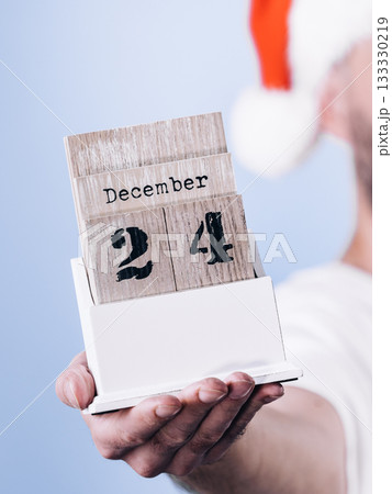 December 24th. Man santa hat holds calender December 24th. Man santa hat holds calender 133330219