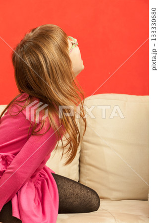 Young toddler girl playing on sofa 133330680