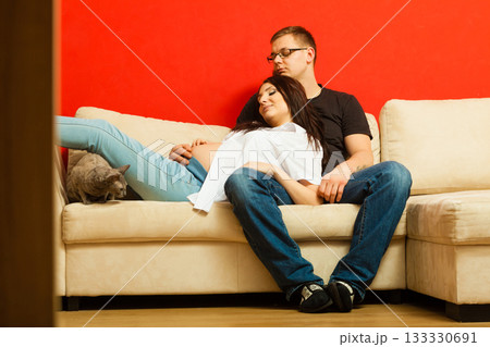 Pregnant woman and man relaxing on sofa 133330691