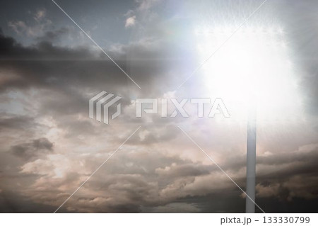 Floodlight tower is glowing with lamp array against layered peach and gray sky in flat design Floodlight tower is glowing with lamp array against layered peach and gray sky in flat design 133330799