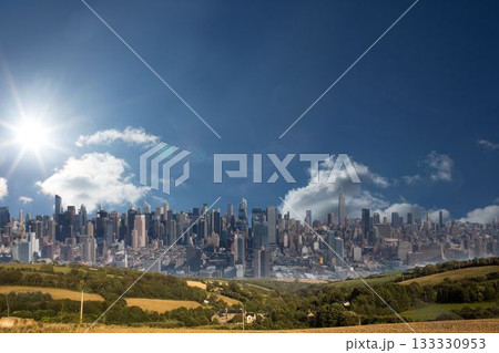 Flat design city skyline merging into rolling green fields with farmhouses, trees under shining sun 133330953