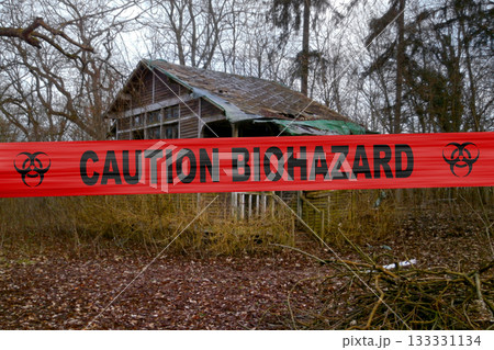 Caution biohazard cordon tape outside an abandoned cabin in the woods Caution biohazard cordon tape outside an abandoned cabin in the woods 133331134