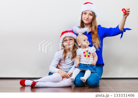 Mother and daughters in christmas outfit Mother and daughters in christmas outfit 133331406