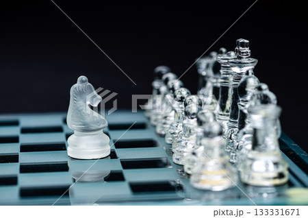transparent glass chess on dark background, selective focus on horse piece, close-up transparent glass chess on dark background, selective focus on horse piece, close-up 133331671