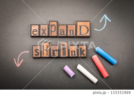 Words Expand and Shrink Written with Wooden Letter Blocks on Blackboard Representing Growth and 133331989