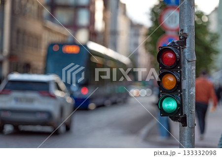 view of city traffic with traffic lights, in the foreground a semaphore with a green light, closeup 133332098
