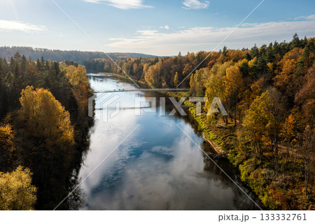 pedestrian bridge over the river Gauja near the devil cliff on a autumn day, Krimulda, Latvia 133332761
