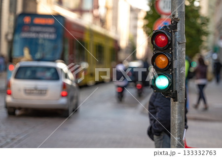 view of city traffic with traffic lights, in the foreground a semaphore with a green light, closeup view of city traffic with traffic lights, in the foreground a semaphore with a green light, closeup 133332763