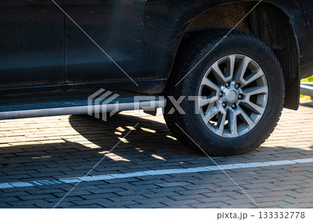 SUV fragment with rear wheel, car shadow on the pavement on a sunny day, close-up SUV fragment with rear wheel, car shadow on the pavement on a sunny day, close-up 133332778