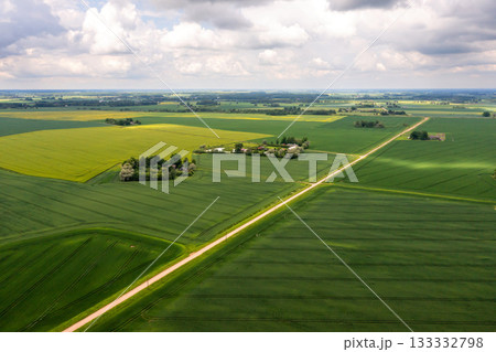 wide countryside before the storm, top view of green agricultural fields and road 133332798