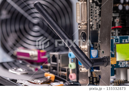 part of computer circuit board with components on the background of defocused power supply fans, close-up 133332873