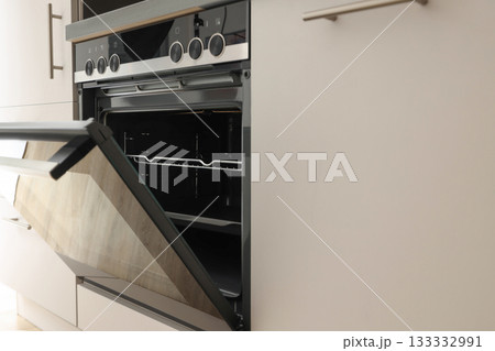 Oven door is open revealing spacious interior and modern design Oven door is open revealing spacious interior and modern design 133332991