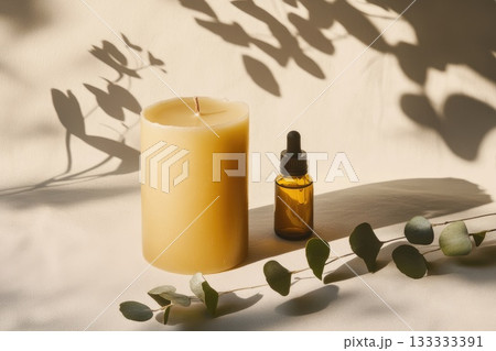 A candle placed alongside a bottle of essential oil is sitting on a table. AI-generated content. 133333391