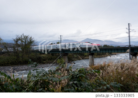 【秋田新幹線】夕暮れの橋梁を通過する特急こまち 133333905