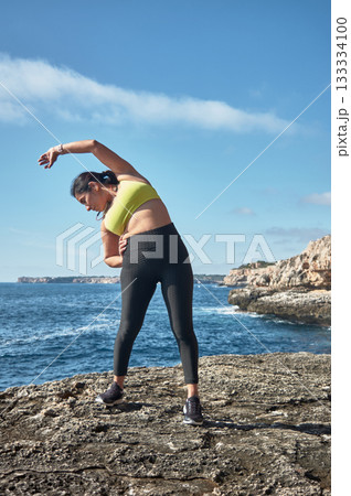 young woman doing yoga on the beach 133334100