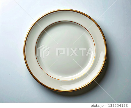 Formal table setting. Ceramic plate with a classic white and gold design on a white background. Porcelain kitchenware. Close-up. Top view. Formal table setting. Ceramic plate with a classic white and gold design on a white background. Porcelain kitchenware. Close-up. Top view. 133334138