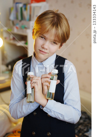 Child holding diffuser liquid bottles in cozy bedroom 133334143