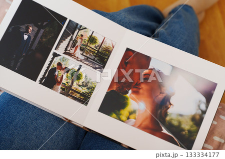Female hands flipping through a photo book with wedding photos Female hands flipping through a photo book with wedding photos 133334177