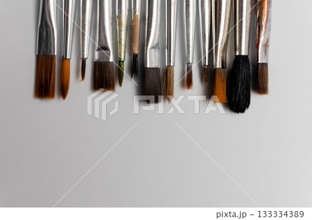 Close up of a group of artist brushes on a white table. The brushes are of different sizes and materials. Art supplies 133334389