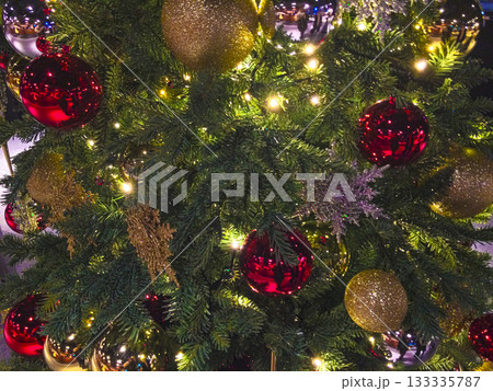 夜ライトアップされ光り輝くモミの木のクリスマスツリーとオーナメントのクロースアップ 屋外2 夜ライトアップされ光り輝くモミの木のクリスマスツリーとオーナメントのクロースアップ 屋外2 133335787