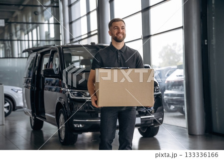 Fast delivery service, standing. Man loader is near the car with a box 133336166