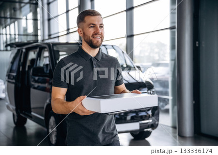 Delivery man or loader is near the car with a box Delivery man or loader is near the car with a box 133336174