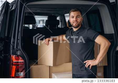 Bunch of boxes. Delivery man or loader is near the car 133336183