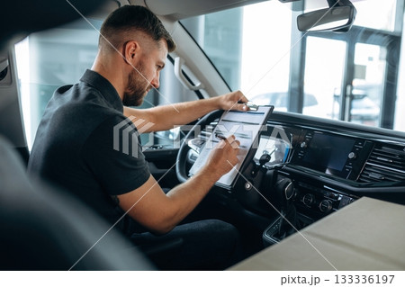 Fulfill the document. Man is sitting in the car, driver 133336197