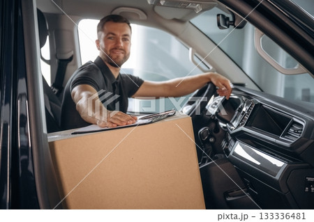 The delivery man or a loader is in the car with box The delivery man or a loader is in the car with box 133336481
