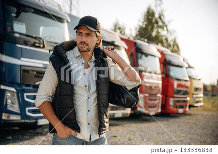 Model in cap is posing. Truck driver is near the transport outdoors 133336838