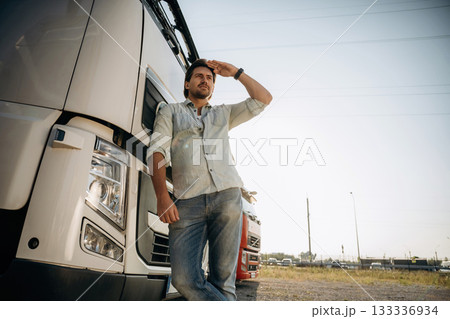View from below, standing and posing. Truck driver is near the transport outdoors 133336934