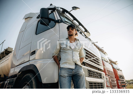 View from below, standing and posing. Truck driver is near the transport outdoors 133336935
