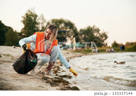 Woman volunteer is against trash pollution outdoors 133337144
