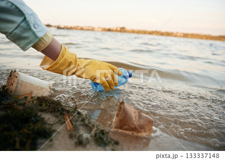 Close up view of female volunteer that is holding plastic bottle, trash pollution 133337148