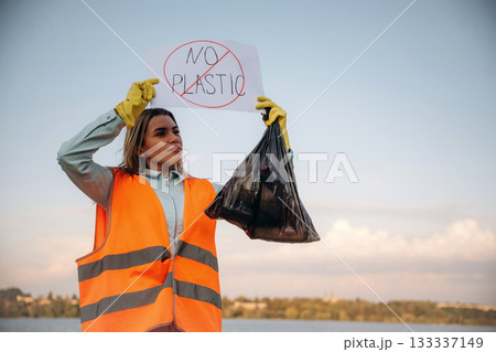 'No plastic' sign in hands. Woman volunteer is against trash pollution outdoors 'No plastic' sign in hands. Woman volunteer is against trash pollution outdoors 133337149