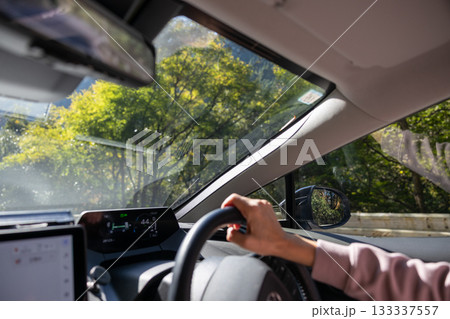 秋の山道を運転している男性の手元 133337557