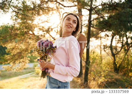 Heartfelt feelings, with bouquet with flowers. Woman is outdoors in nature with bouquet of flowers 133337569