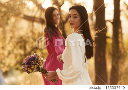 Looking behind. Lovely lesbian couple are together outdoors in nature Looking behind. Lovely lesbian couple are together outdoors in nature 133337640