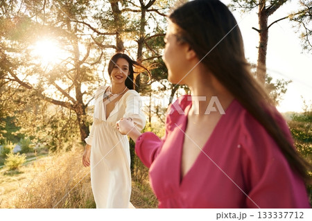 Side view, having a walk. Lovely lesbian couple are together outdoors in nature Side view, having a walk. Lovely lesbian couple are together outdoors in nature 133337712
