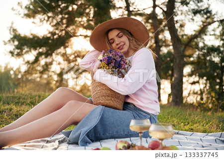 Embracing the bouquet of flowers. Woman is outdoors in nature with bouquet of flowers Embracing the bouquet of flowers. Woman is outdoors in nature with bouquet of flowers 133337745
