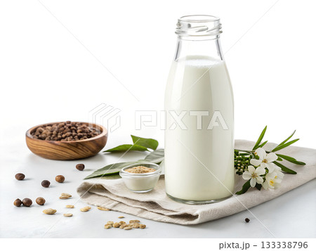 Glass bottle of plant based milk with ingredients nuts seeds and delicate white flowers on cloth Glass bottle of plant based milk with ingredients nuts seeds and delicate white flowers on cloth 133338796