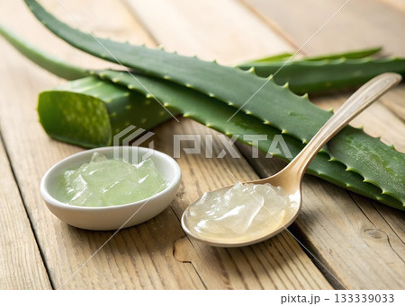 Fresh aloe vera leaves and gel in a bowl and spoon on a wooden table plant 133339033