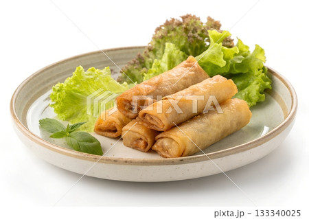 Crispy golden spring rolls served with fresh green lettuce and a basil leaf on a plate Crispy golden spring rolls served with fresh green lettuce and a basil leaf on a plate 133340025