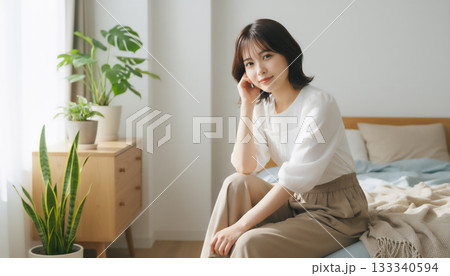 自然光あふれる白い部屋で過ごす穏やかな女性のポートレート 133340594