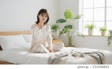 自然光あふれる白い部屋で過ごす穏やかな女性のポートレート 133340603