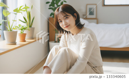自然光あふれる白い部屋で過ごす穏やかな女性のポートレート 133340605