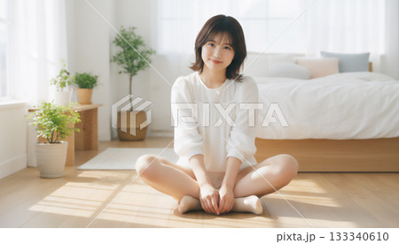 自然光あふれる白い部屋で過ごす穏やかな女性のポートレート 133340610